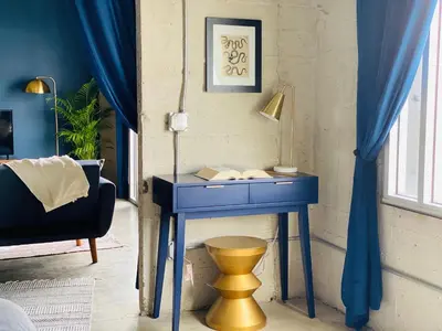 a blue desk in a room with a lamp and a chair at THE MIDNIGHT LOFT BY BOBOU DESIGN (KING SUITE) in Los Angeles