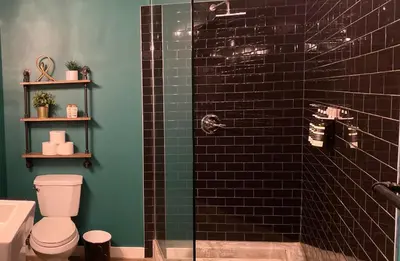 a bathroom with a toilet and a glass shower at THE MIDNIGHT LOFT BY BOBOU DESIGN (KING SUITE) in Los Angeles