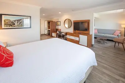 a hotel room with a large bed and a television at Pasadena Rose & Crown Hotel in Pasadena