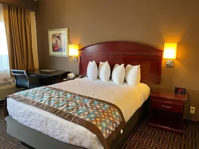 a hotel room with a large bed with white pillows at Best Western Pasadena Inn in Pasadena