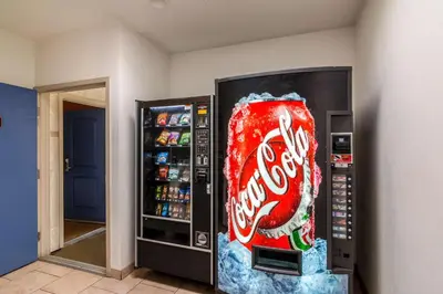 a cocacola soda vending machine with a can of coke at Motel 6 Bell Gardens, CA - Los Angeles in Bell Gardens