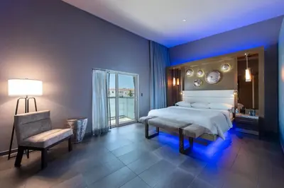 a bedroom with a bed and a chair and a window at Shade Hotel Manhattan Beach in Manhattan Beach