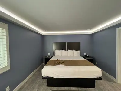 a bedroom with a large bed with blue walls at Deluxe Inn Hawthorne/ LAX in Hawthorne
