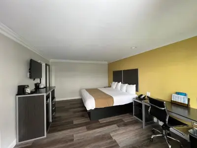 a hotel room with a bed and a desk at Deluxe Inn Hawthorne/ LAX in Hawthorne
