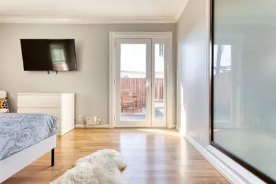 a bedroom with a bed and a sliding glass door at New Belmont Shore Retreat with free Parking Walk to Beaches in Long Beach