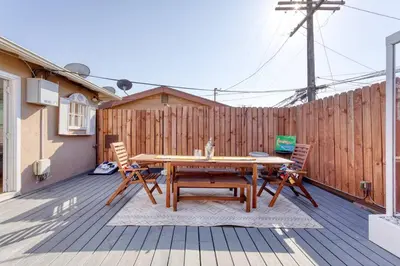 a wooden deck with a wooden table and chairs at New Belmont Shore Retreat with free Parking Walk to Beaches in Long Beach