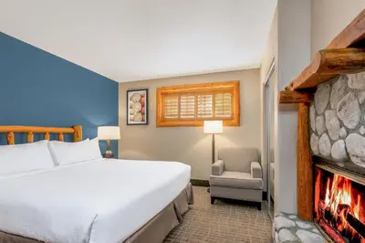 a bedroom with a large bed and a fireplace at Holiday Inn Resort The Lodge at Big Bear Lake by IHG in Big Bear Lake