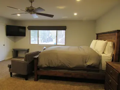 a bedroom with a bed and a chair and a ceiling fan at Monticello in Big Bear Lake