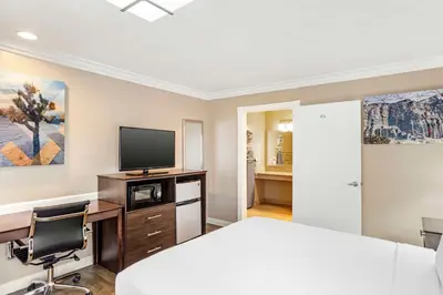 a bedroom with a bed and a desk and a tv at Best Western China Lake Inn in Ridgecrest