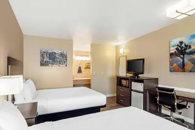 a hotel room with two beds and a flat screen tv at Best Western China Lake Inn in Ridgecrest