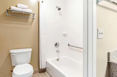 a bathroom with a white toilet and a bath tub at Best Western China Lake Inn in Ridgecrest