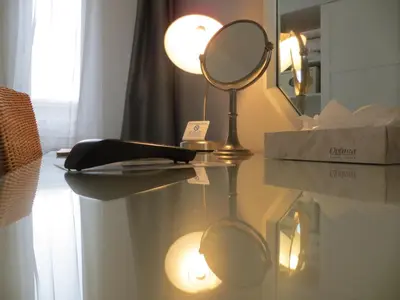 a mirror on a glass table with a lamp and a mirror at Bayside Hotel in Los Angeles