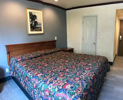 a bedroom with a bed with a colorful bedspread at Starlight Inn Canoga Park in Canoga Park