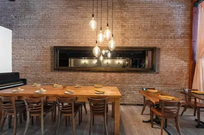 a dining room with a wooden table and a brick wall at The O Hotel, Trademark Collection by Wyndham in Los Angeles