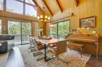 a living room with a table and a piano at Lake Arrowhead Family Home with Game Room in Lake Arrowhead