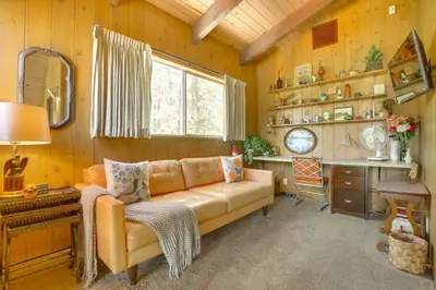 a living room with a couch and a desk at Lake Arrowhead Family Home with Game Room in Lake Arrowhead
