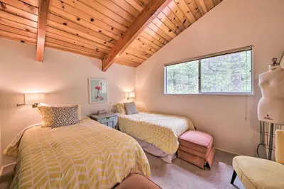 a bedroom with two beds and a window at Lake Arrowhead A-Frame House with Private Hot Tub! in Lake Arrowhead