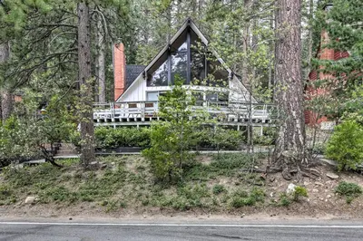 a house in the woods with a porch at Lake Arrowhead A-Frame House with Private Hot Tub! in Lake Arrowhead