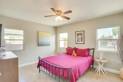 a bedroom with a pink bed and a ceiling fan at Fullerton Vacation Rental with Private Pool! in Fullerton