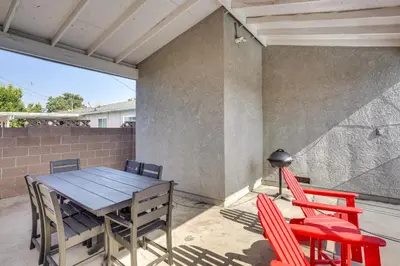 a patio with a wooden table and red chairs at Fullerton Vacation Rental with Private Pool! in Fullerton