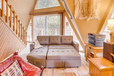 a living room with a couch and a window at Star House Unique Home with 360 Mountain Views! in Pine Mountain Club