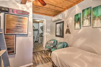 a bedroom with a bed and a chair in it at Remodeled Crestline Retreat Walk to Lake Gregory! in Crestline