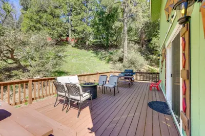 a deck with chairs and tables on a house at Remodeled Crestline Retreat Walk to Lake Gregory! in Crestline