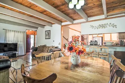 a dining room and living room with a table and chairs at 5 Mi to Lake Arrowhead Village Cabin with Game Room in Lake Arrowhead