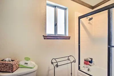 a bathroom with a shower and a toilet and a window at 5 Mi to Lake Arrowhead Village Cabin with Game Room in Lake Arrowhead