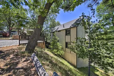 a house with a tree and a fence at Family Cabin with Game Room Near Hiking and Skiing! in Lake Arrowhead