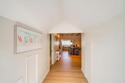a hallway of a home with white walls and wooden floors at Victorian Carpinteria Apartment Less Than 1 Mi to Beach! in Carpinteria