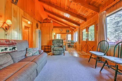 a living room with a couch and a table and chairs at Big Bear Lake Cabin with Deck about 7 Mi to Ski Slopes! in Fawnskin