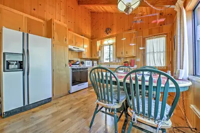 a kitchen with a table and chairs and a refrigerator at Big Bear Lake Cabin with Deck about 7 Mi to Ski Slopes! in Fawnskin