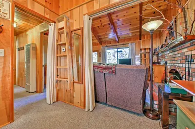a room with wooden walls and a room with a ladder at Big Bear Lake Cabin with Deck about 7 Mi to Ski Slopes! in Fawnskin