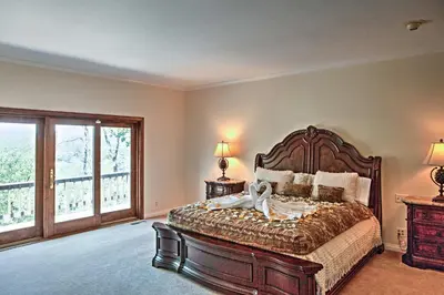 a bedroom with a large bed and a large window at Lake Arrowhead House with Lake Views and Wet Bar! in Lake Arrowhead