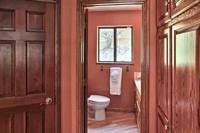 a bathroom with a toilet and a window at Lake Arrowhead House with Lake Views and Wet Bar! in Lake Arrowhead