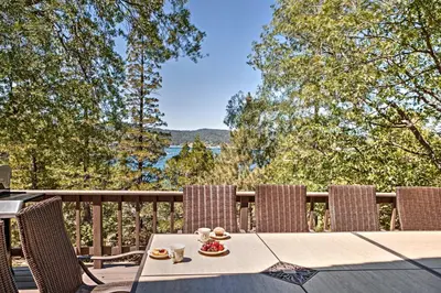 a table and chairs on a deck with a view at Lake Arrowhead House with Lake Views and Wet Bar! in Lake Arrowhead