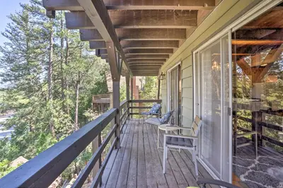 a porch with a bench and chairs on a house at A-Frame Home with 3 Decks and Lake Arrowhead Views! in Lake Arrowhead