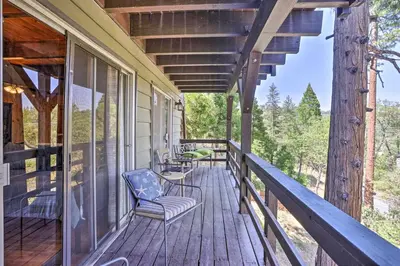 a porch of a house with a chair and a view at A-Frame Home with 3 Decks and Lake Arrowhead Views! in Lake Arrowhead