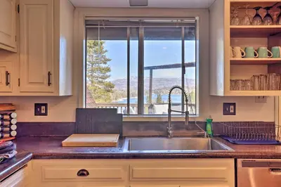 a kitchen with a sink and a large window at A-Frame Home with 3 Decks and Lake Arrowhead Views! in Lake Arrowhead