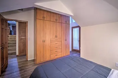 a large bedroom with wooden cabinets and a bed at Lake Arrowhead Family Home with Deck! in Lake Arrowhead