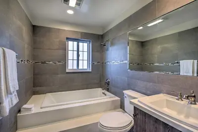 a bathroom with a tub and a toilet and a sink at The Castle Hacienda Heights Home with Patio and Pool in Hacienda Heights
