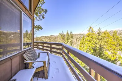 a balcony with a bench and a view of the mountains at Cabin with Mtn Views and Deck, 5 Min To Arrowbear Lake! in Arrowbear Lake