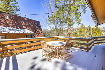 a patio with a table and chairs on a balcony at Cabin with Mtn Views and Deck, 5 Min To Arrowbear Lake! in Arrowbear Lake