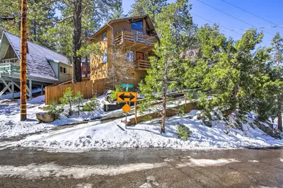 a log home in the snow with a sign in front at Cabin with Mtn Views and Deck, 5 Min To Arrowbear Lake! in Arrowbear Lake