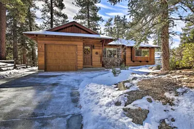 a log cabin in the woods in the snow at Walk to Lake Rustic Home with Deck in Fawnskin in Fawnskin