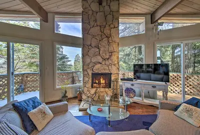 a living room with a fireplace and a tv at Lake Arrowhead Cabin with Deck and Scenic Forest Views in Lake Arrowhead