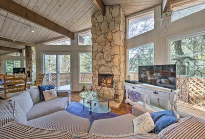 a living room with a couch and a fireplace at Lake Arrowhead Cabin with Deck and Scenic Forest Views in Lake Arrowhead