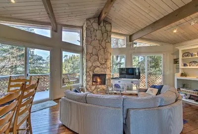 a living room with a couch and a fireplace at Lake Arrowhead Cabin with Deck and Scenic Forest Views in Lake Arrowhead