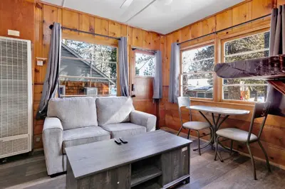 a living room with a couch and a table at Juniper Lakeside Couples Resort Cabin by Big Bear Vacations in Big Bear Lake